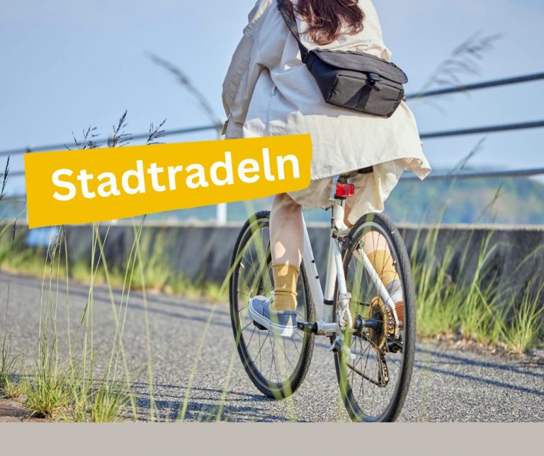 Eine Frau auf einem Fahrrad fährt auf einem Weg.