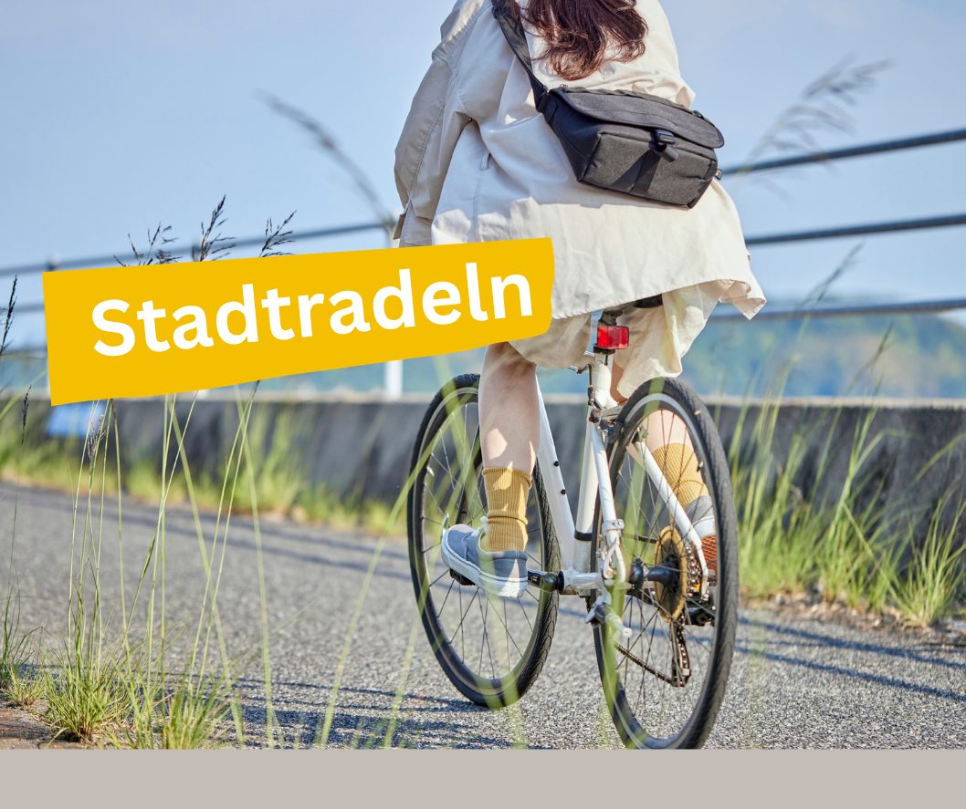 Eine Frau auf einem Fahrrad fährt auf einem Weg.